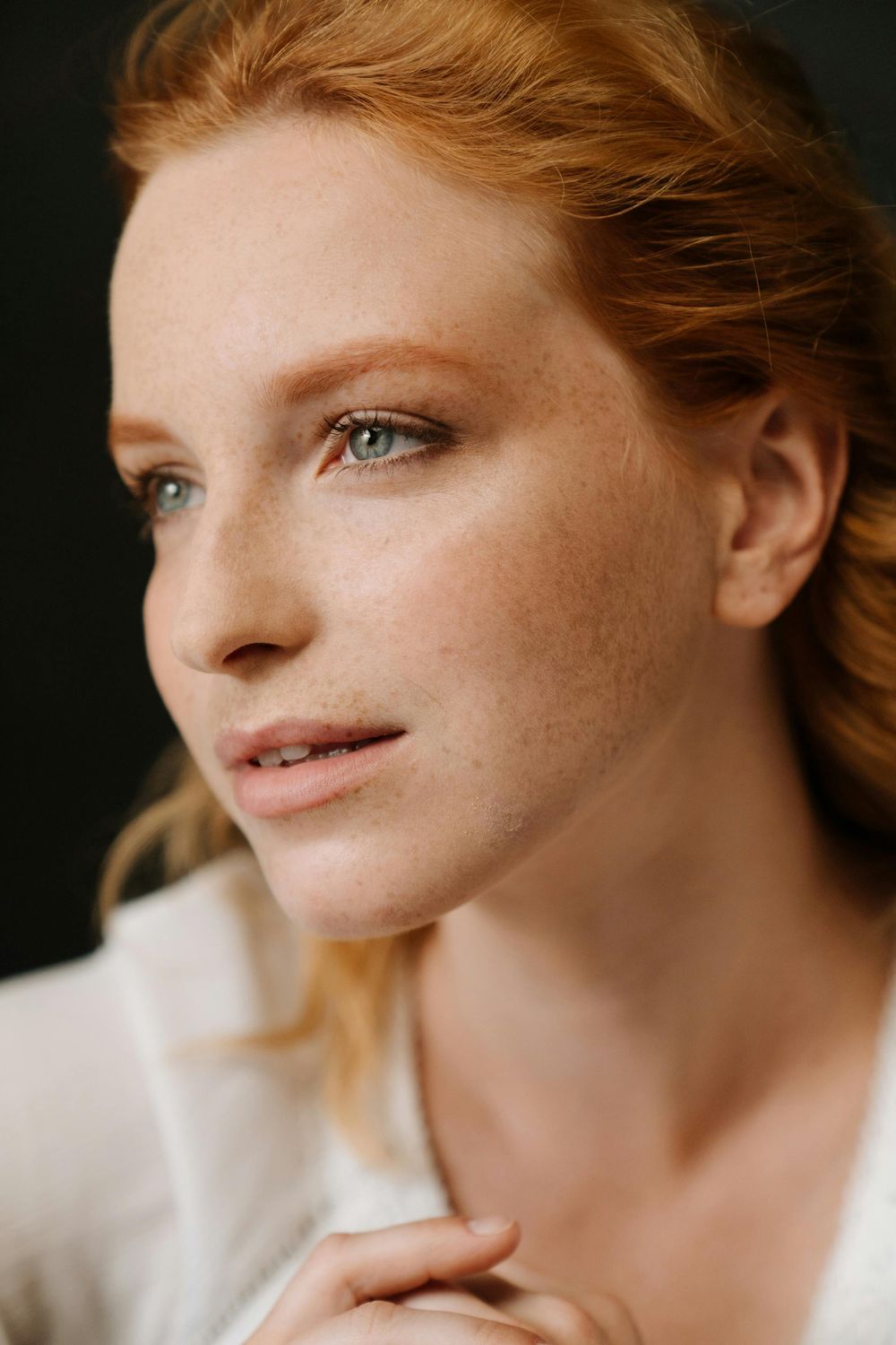 Woman with blonde hair resting her chin.
