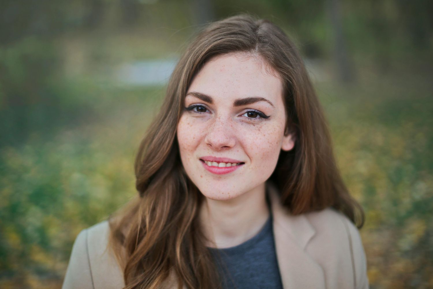 Smiling woman with long hair outdoors.